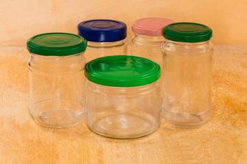 Empty small glass jars different sizes closed with multicolored lids