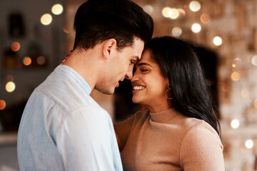 Love, romance and couple hugging while on a date for valentines day or anniversary celebration. Happy, intimate and young interracial man and woman embracing while at romantic evening dinner together