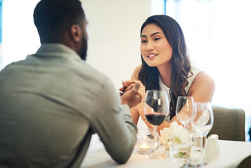 Couple, holding hands and wine in restaurant with talking, love and romance for valentines day date in night. Black man, asian woman and conversation for bonding, luxury fine dining and celebration