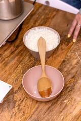 Soy candle creation workshop. Bowl with soy wax pearls and wooden spoon.