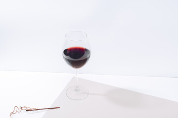 A glass of red wine on the table. Light background.