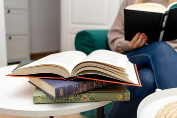 International Book Day. Education. International Literacy Day. Books on the table with a woman reading in the background.