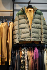 olive color men's spring jacket on a hanger in a clothing store
