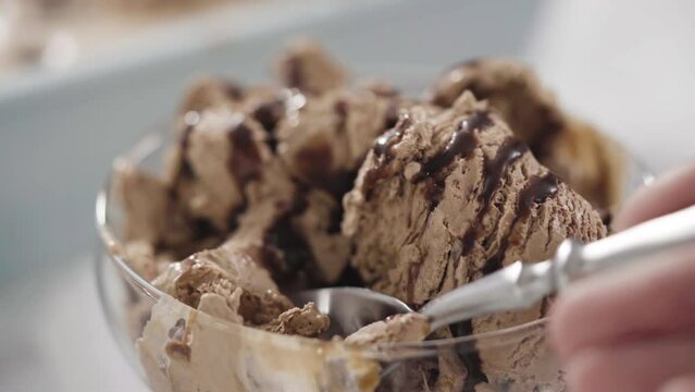 Close up view. Homemade chocolate ice cream garnished with chocolate in a glass ice cream bowl.