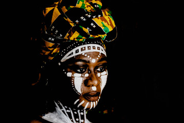 African woman in portrait with face painting and headdress.