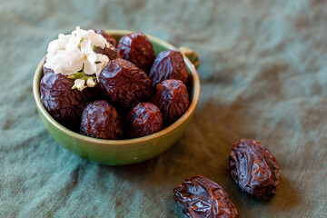 Bowl of date fruits on a wooden table