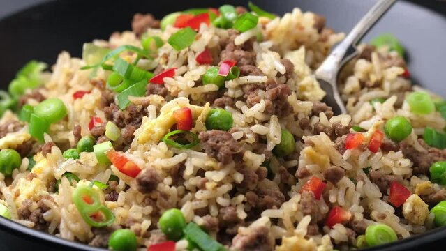Eating Beef Fried Rice with tablespoon. Asian healthy food