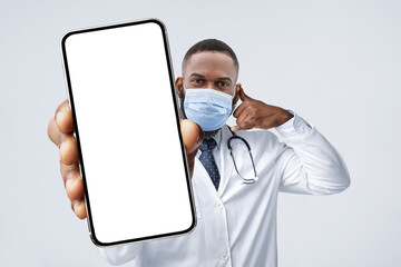 Online Consultation. Black Male Doctor Holding Blank Smartphone And Gesturing Call Me