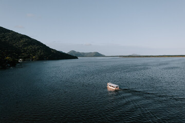 Fototapeta na wymiar Ein Boot - Fähre auf dem See Lagoa da Conceição auf der Insel Florianopolis. Ein See direkt am Meer Drohne 5