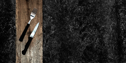 Topview of Set of Fork, Knife and Cutting Board on Dark Background