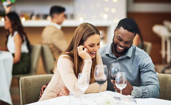 Date, Laughing And Interracial Couple With Wine In Fine Dining, Luxury Restaurant Or Valentines Celebration Together. Funny Black Man, Happy Woman And Alcohol Glasses For Romance, Rich Or Anniversary