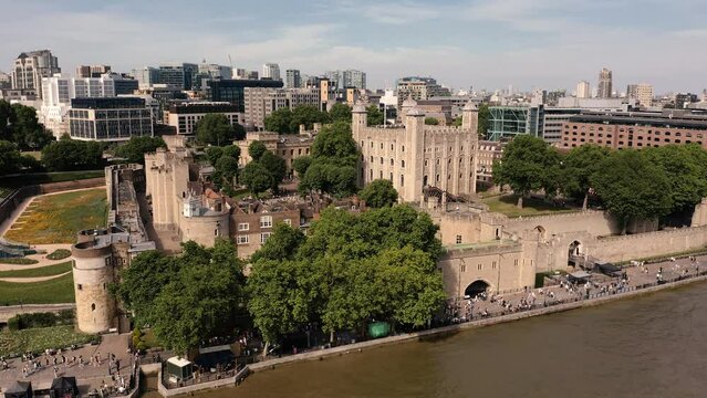 Drone shot circling The Tower of London on a hot Summers day over the River Thames bustling with Tourists