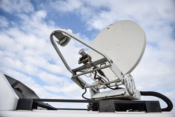 Satellite antenna on a mobile news television truck with blue cloudy sky on the background - 569150140