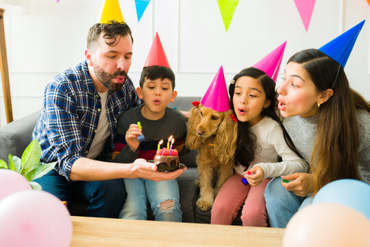 Beautiful Family Blowing The Birthday Candles Together