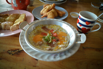 Fried eggs in small pan with minced pork and vegetable on top and breakfast time.