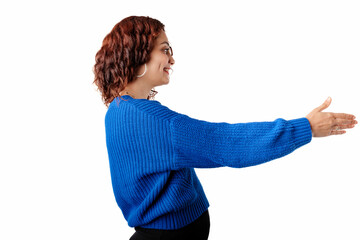 Woman wearing sweater standing isolated over white background giving hand for handshake, greeting with smile. The concept of meeting. Holds out hand to the empty copy space and wants to shake hands.