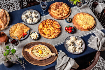 Traditional Georgian Adjara khachapuri, manti and  on the table. Food Table Celebration Delicious Party Meal Concept. 