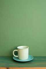 Coffee cup on wooden table. green wall background. minimal, copy space