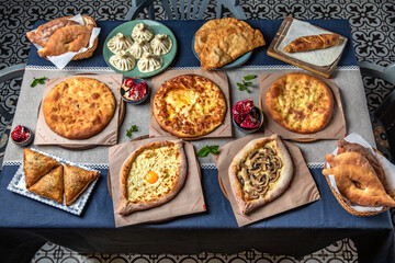 Traditional Georgian Adjara khachapuri, manti  on the table. Food Table Celebration Delicious Party Meal Concept. 