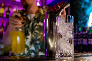 empty glass with ice on a bar counter in bar or pub