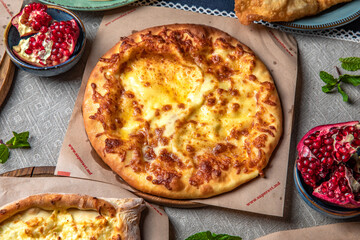 Traditional Georgian Adjara khachapuri, manti and Kolkh khachapuri on the table. Food Table Celebration Delicious Party Meal Concept. 