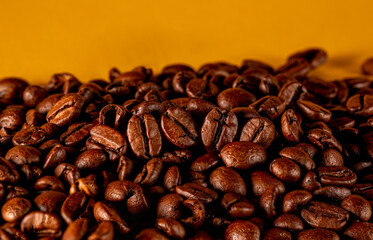 Roasted coffee beans on golden background