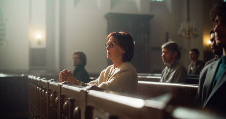 Group Of Faithful Parishioners In Grand Old Church Listening to Sermon. Devout Christian Lady with...