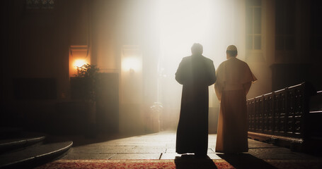 In The Church, A Priest And Pope Share A Conversation Of Faith, Reverence, Hope, Discussing Gospels and Teaching of Jesus Christ and Holy Book. Blessing Light From Tainted Window Shines on Them. - obrazy, fototapety, plakaty