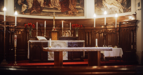 Wide Shot of a Beautifully Decorated Altar in a Grand Church. Candles, Flowers, Paintings and the Whole Bible Surrounding a Cross with a statue of the Lords Jesus Christ. Place of Faith and Prayer