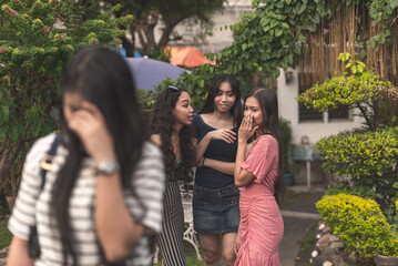 A clique of three mean girls talk and bad-mouth about a poor woman who leaves in shame. Bullying in...