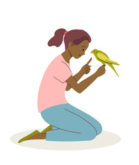 Girl plays and teach parrot to talk. Pet care concept.