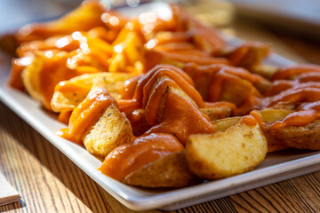 A close up of a plate of patatas bravas ready for al fresco dining