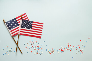 USA Independence Day concept with American flags, red, white and blue star confetti on blue...
