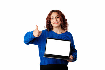 Naklejka premium Young woman wearing blue pullover sweater isolated over white background holding a laptop with a blank white mockup screen, smiles at the camera and gives a thumbs-up sign.