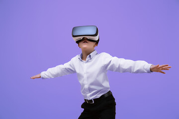 Schoolboy plays video game while using VR headset on purple background. Child in virtual goggles. 