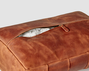 Hand-stitched copper-colored leather footrest with zipper and holofiber filling