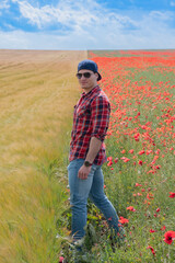 Young Man wearing Red for Valentines day, posing in Flower Field with Poppies. Love and Romance