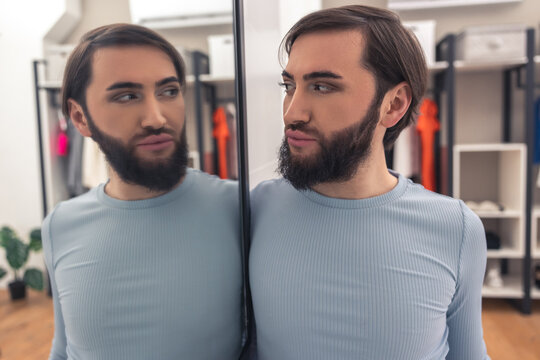 Male examining his mirror reflection after the makeup application