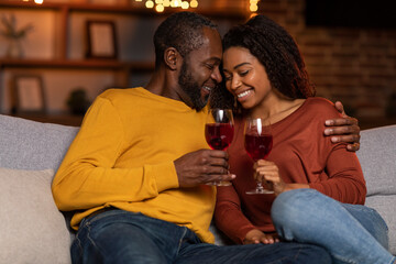 Loving black husband hugging his pretty wife, home interior