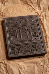 Unpacked Chinese tea brick from the Hubei Province close up on package paper