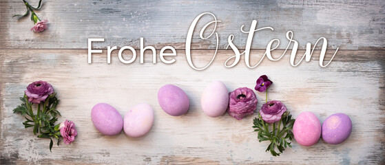 Fototapeta na wymiar Happy easter greetings with violet easter eggs and purple ranunculus on vintage wood. Horizontal background for greeting cards and banner with German text. Top view.