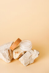 Cosmetic jar wooden lid with cream or lotion on stone podium for product presentation. Skincare cosmetic. yellow background. Beauty concept for face care
