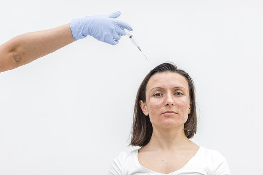 Close up photo of woman with dry skin and hand in medical glove with injection.