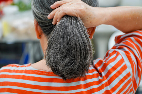 Asian Elderly Woman Tying Up Beautiful Gray Hair