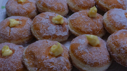 Homemade fried donuts filled with custard and seasoned with a veil of sugar
