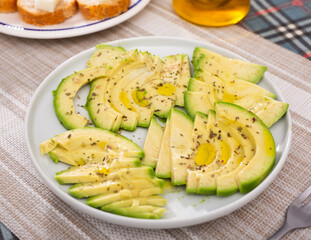 ripe avocado pulp cut into pieces sprinkled with lemon juice on a plate