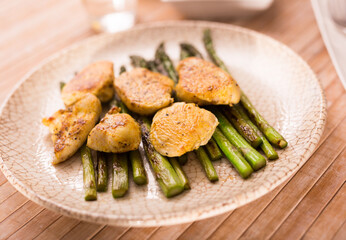 fried chicken breast pieces with asparagus on white plate