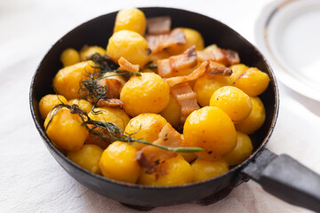 young potatoes with pork belly fried in frying pan
