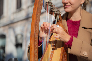 Belgrade, Serbia. November 10th, 2022. Street musician woman playing harp in a pedestrian street in Belgrade.