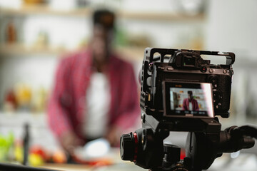 African man filming cooking vlog. Happy man filming his blog about healthy food at home.